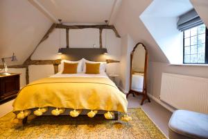 布罗德韦Cotswolds Place - Chancewell的一间卧室配有一张带黄色床罩的大床