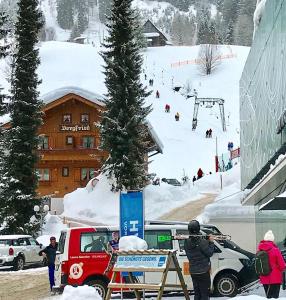 里茨勒恩Das Bergfried - Urlaub zentral und ruhig!的一群人站在滑雪小屋附近的雪地里