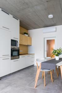 布拉格Residence Trafick的厨房配有白色橱柜和桌椅