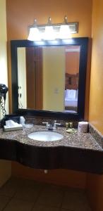安大略Lotus by Hotel Inn的一间带水槽和大镜子的浴室