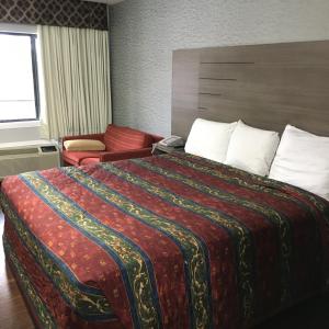 亨博尔旅游套房汽车旅馆的酒店客房设有一张带红色毯子的大床