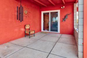 二十九棕榈村Chuck's Cabin in a Joshua Tree Community的红色的房间,配有椅子和门