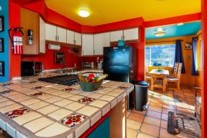 二十九棕榈村Chuck's Cabin in a Joshua Tree Community的厨房设有红色和黄色的墙壁和台面