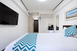 东京新宿G住宿公寓的一间卧室配有一张大床和一台平面电视