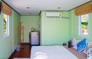 哈林海滩Hill Zone Home Stay by Little Paradise的卧室设有白色的床和绿色的墙壁
