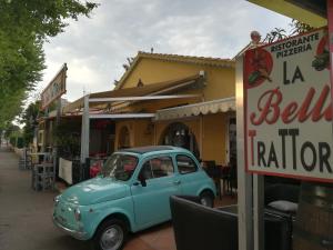 弗雷瑞斯Atoll Hotel restaurant的停在餐厅前面的旧蓝色汽车