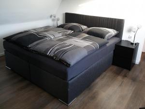 博霍尔特Ferienwohnung Berger Bocholt的卧室内的一张大床和一张黑色床架