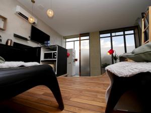 格勒诺布尔Appartement spa privatif Grenoble At Home Spa的客厅铺有木地板,设有大窗户。
