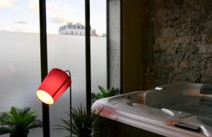 格勒诺布尔Appartement spa privatif Grenoble At Home Spa的浴缸旁的红灯浴室