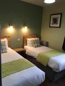 瓦利The Valley Hotel, Anglesey的酒店客房,配有两张带绿床单的床