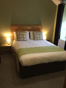 瓦利The Valley Hotel, Anglesey的一间卧室配有一张大床和两盏灯