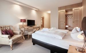 诺伊基兴多娜布和歌酒店的一间卧室配有一张床、一张桌子和一把椅子