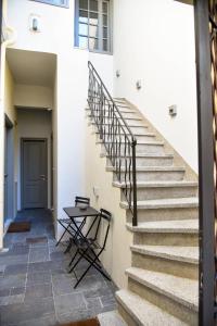雅典Erst Guest House的白色建筑中的一个楼梯,有桌子