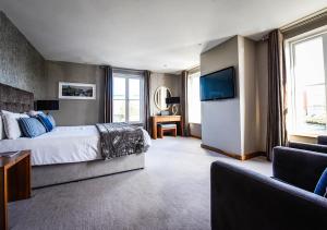 戈尔韦猎人旅馆的一间卧室配有一张床、一台电视和一张沙发