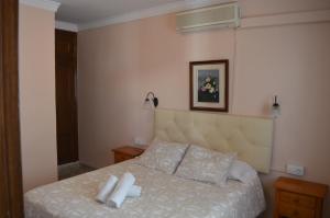 隆达Hotel Doña Carmen的一间卧室配有一张带两条白色毛巾的床