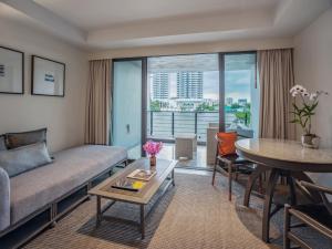 曼谷曼谷里瓦苏里亚酒店 - SHA Extra Plus的客厅配有沙发和桌子