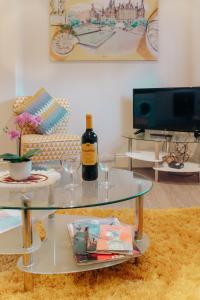 谢菲尔德太空萨韦尔公寓的玻璃桌,配有一瓶葡萄酒和酒杯