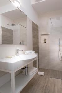 朱利亚诺瓦YOUMAMI Suite Hotel的白色的浴室设有水槽和镜子