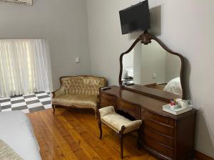 布隆方丹Boutique@Milner Guesthouse的一间卧室配有带镜子和椅子的梳妆台