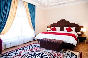 TürkistanBoutique Hotel Silk Way的一间卧室配有一张带红色和白色枕头的大床