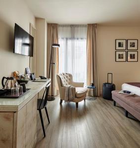 巴塞罗那巴塞罗纳卡泰多拉尔酒店的酒店客房配有一张桌子、一把椅子和一张床
