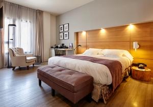 巴塞罗那巴塞罗纳卡泰多拉尔酒店的酒店客房带一张大床和一把椅子