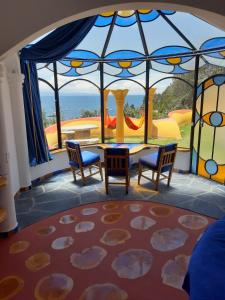 科帕卡巴纳Hostal Las Olas的客房设有桌椅和大窗户。