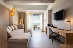 尼坡帝Portes Lithos Luxury Resort的客厅配有沙发和书桌及电视