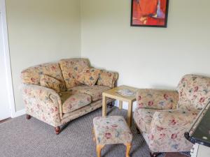 巴利霍尼斯Glor Cottage的客厅配有沙发和桌子