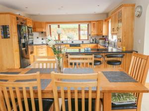 法伦福尔Rossanean的厨房配有木制橱柜和一张带椅子的木桌
