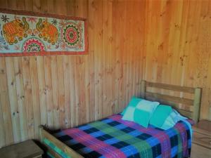 孔斯蒂图西翁Hostal Casona del Cerro的卧室配有木墙内的一张床