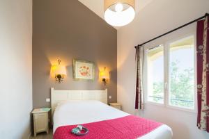 格罗斯皮耶尔雷Village Pierre & Vacances Le Rouret的一间卧室配有一张带粉色毯子的床和窗户。