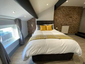 普雷斯顿6Adelphi的一间卧室设有一张大床和砖墙