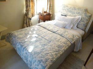 伦敦赫尔林汉姆住宿加早餐旅馆的一间卧室配有一张带蓝色和白色棉被的床