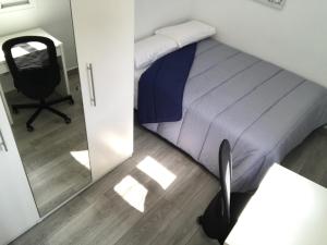萨拉戈萨MODERNO NUEVO Luminoso WI-FI PLAZA DEL PILAR 2的一间卧室配有一张床、一把椅子和镜子