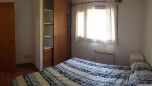 圣卡洛斯-德巴里洛切Departamento Victoria Bariloche的一间卧室设有一张床和一个窗口