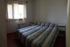 圣卡洛斯-德巴里洛切Departamento Victoria Bariloche的一间卧室配有一张带床罩的床和窗户