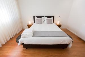 布拉加Braga Luxury Residence 3854的一间卧室配有一张带两盏灯的大型白色床。