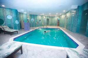 巴库Parkway Inn Hotel & Spa的在浴室里的大型游泳池游泳的人