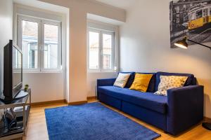 里斯本3 bedroom apt near Av. Liberdade的客厅配有蓝色的沙发和电视