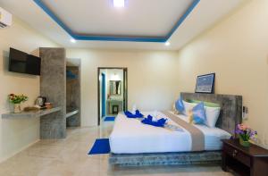 高兰The Sun Long Beach Resort的卧室配有带蓝色枕头的大型白色床
