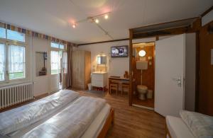 翁根瑞士伯尔米藿夫宾馆的一间卧室配有一张床、一张书桌和一面镜子