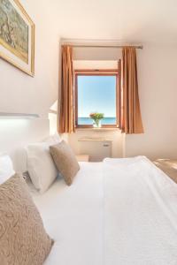 布德瓦R club Apartments Old Town Budva的一间卧室设有两张床和一个海景窗户。