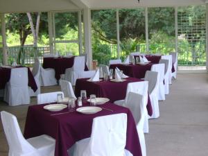 查帕拉查帕拉乡村酒店的一排桌椅,带紫色和白色的桌布
