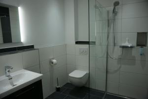 WeyheLeister Apparthotel的带淋浴、卫生间和盥洗盆的浴室