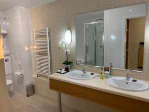 布什米尔斯湾景酒店的一间带两个盥洗盆和大镜子的浴室