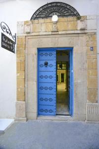 突尼斯达尔雅住宿加早餐旅馆的建筑上带标志的蓝色门