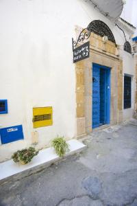 突尼斯达尔雅住宿加早餐旅馆的一座建筑,上面有蓝色的门和标志