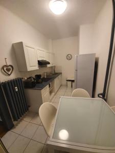 斯特拉斯堡Appartement Strasbourg Cathédrale的厨房配有桌椅和冰箱。