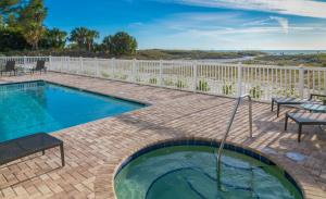 圣徒皮特海滩Provident Oceana Beachfront Suites的一座带白色围栏的砖砌庭院内的游泳池
